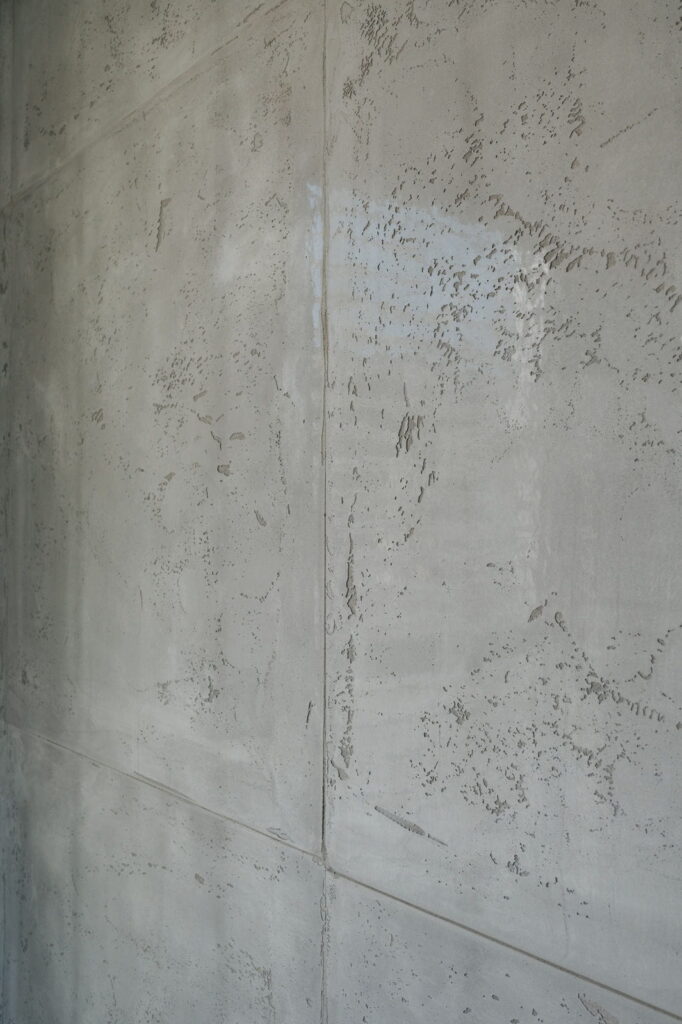 Detailaufnahme einer strukturierten Betonoptik-Wand mit feiner Oberfläche