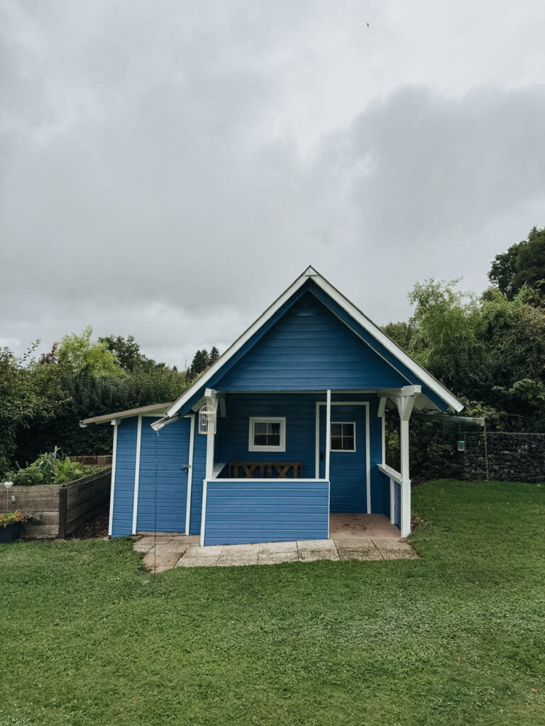 Gartenhütte mit blau-weißem Holzanstrich